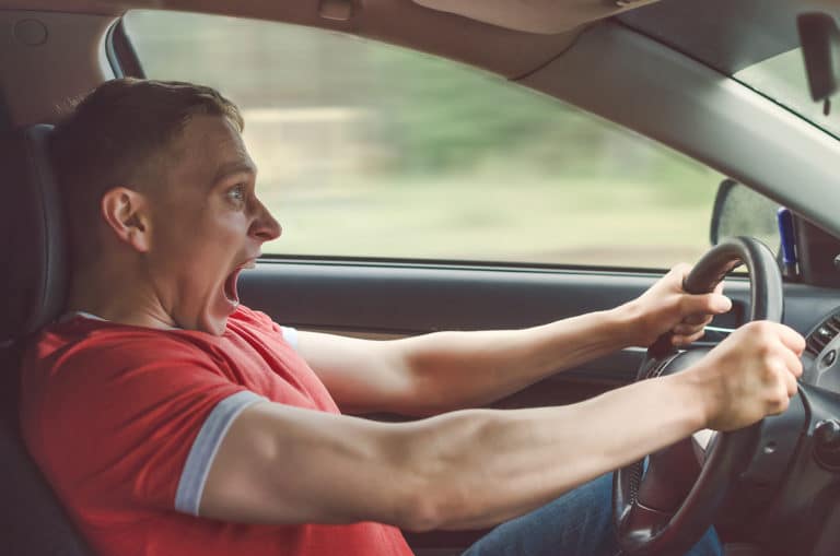 Autofahrer reißt erschrocken das Lenkrad herum, Symbolbild für einen Auffahrunfall im Straßenverkehr